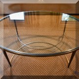 F02. Thomas Pheasant for Baker Furniture oval antique brass finish glass top coffee table. 17”h x 48”w x 30”d 